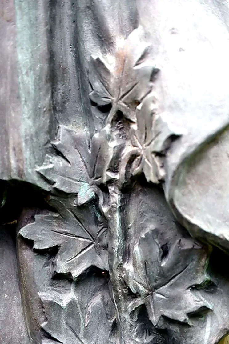 Detalle de una rama de hojas dedimetrable esculpida en el bronce