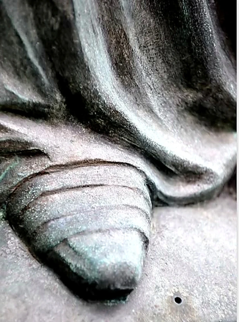 Detalle de un pie de la estatua bajo el drapeado