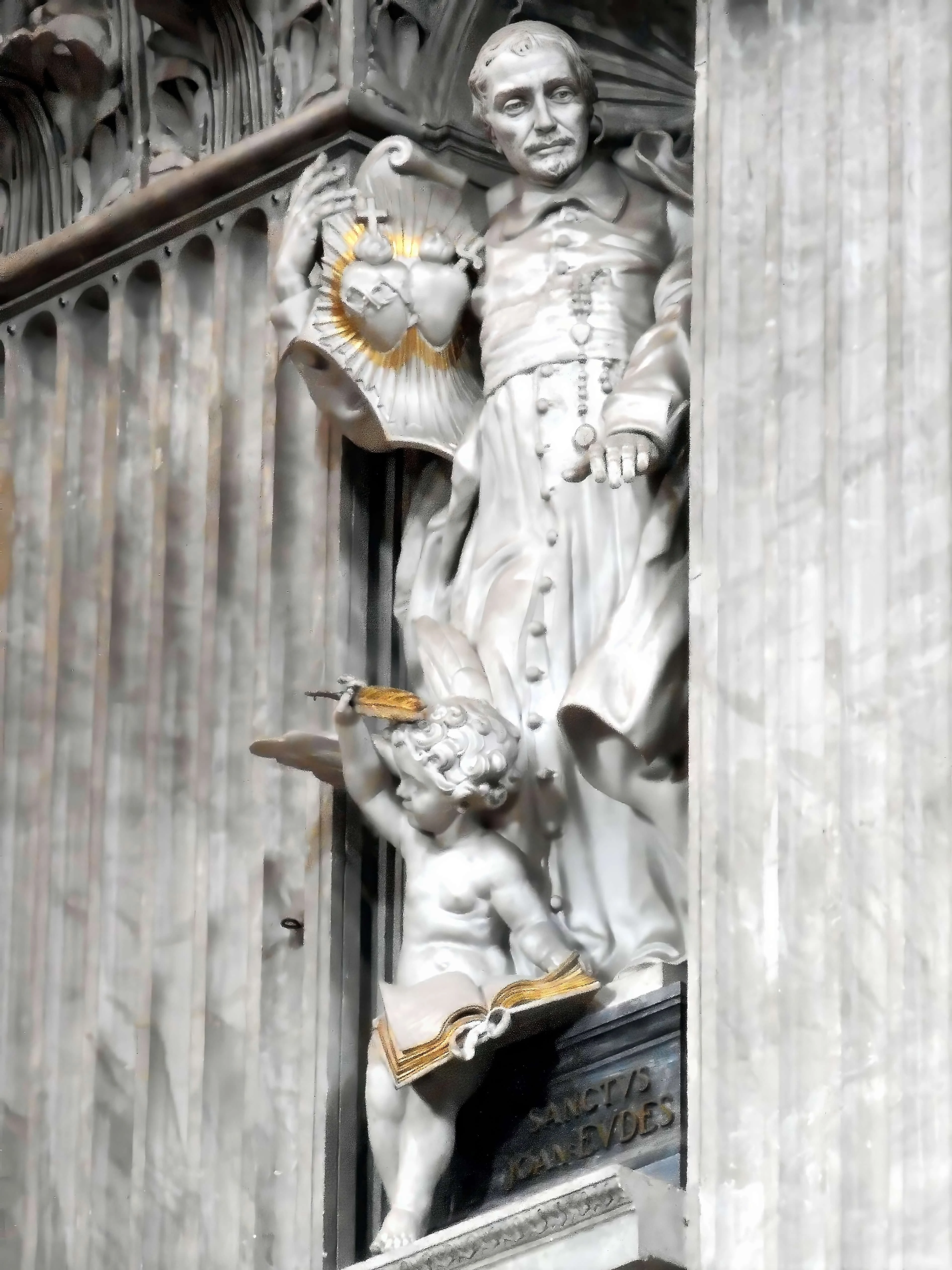 Estatua de san Juan Eudes que sostiene los Corazóns de Jesús y de María